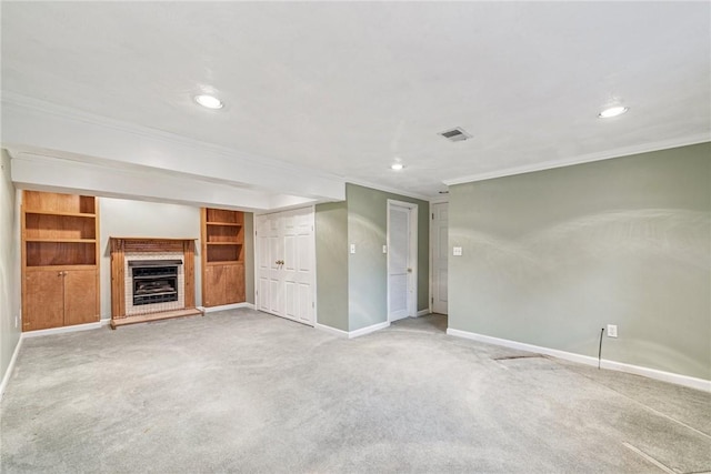 unfurnished living room featuring carpet floors, visible vents, a fireplace with raised hearth, ornamental molding, and baseboards