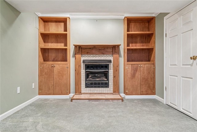 unfurnished living room featuring carpet, a fireplace with raised hearth, and baseboards