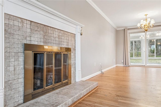 unfurnished living room with a fireplace, an inviting chandelier, ornamental molding, wood finished floors, and baseboards