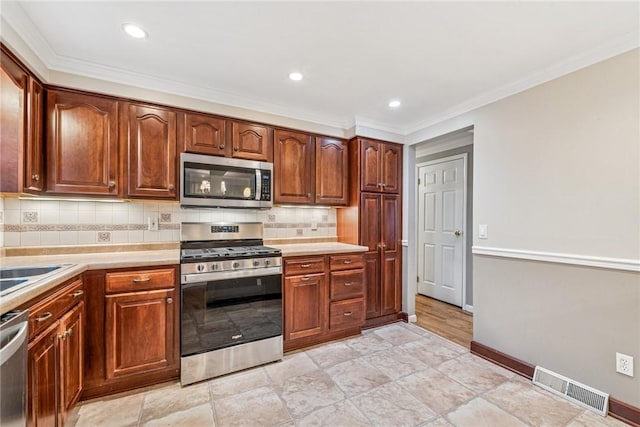 kitchen with stainless steel appliances, visible vents, baseboards, light countertops, and tasteful backsplash