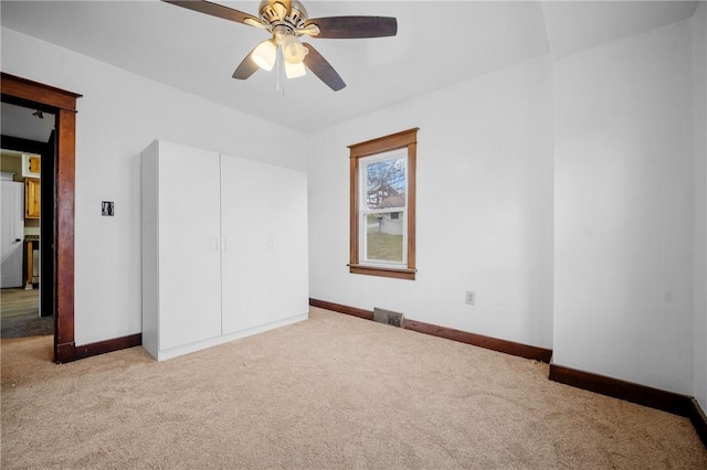 unfurnished bedroom with a ceiling fan, baseboards, and carpet flooring