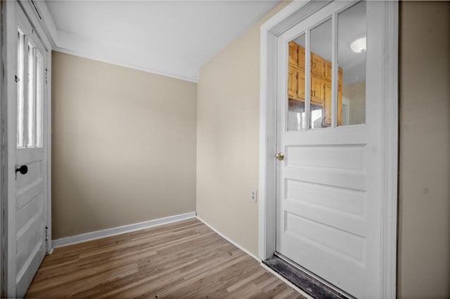 doorway to outside with wood finished floors and baseboards