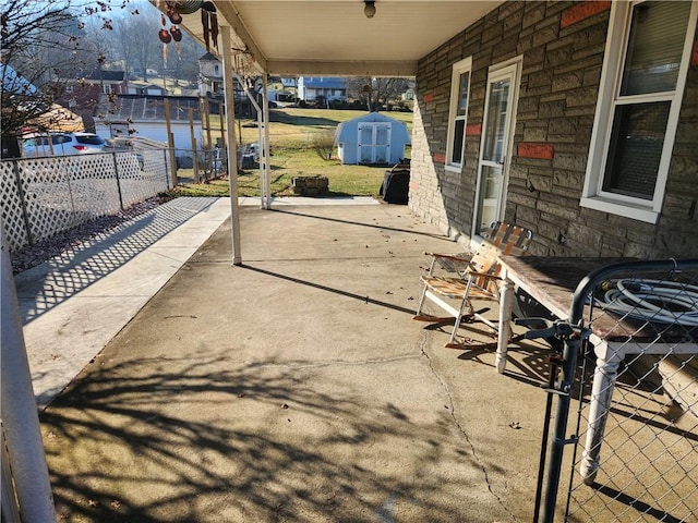 view of patio / terrace featuring an outbuilding and fence