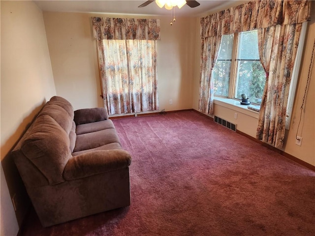 living area with a ceiling fan, carpet, visible vents, and baseboards