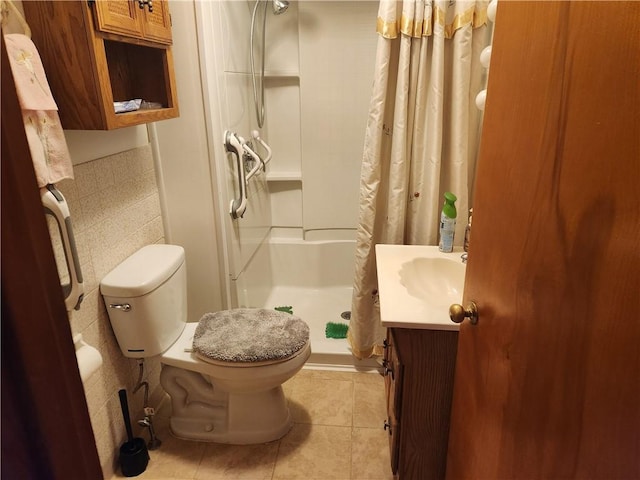 bathroom with toilet, a shower with shower curtain, tile walls, vanity, and tile patterned floors