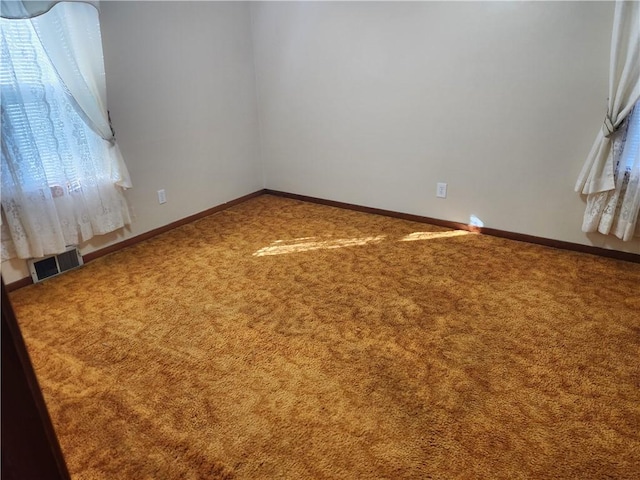 carpeted spare room with visible vents and baseboards