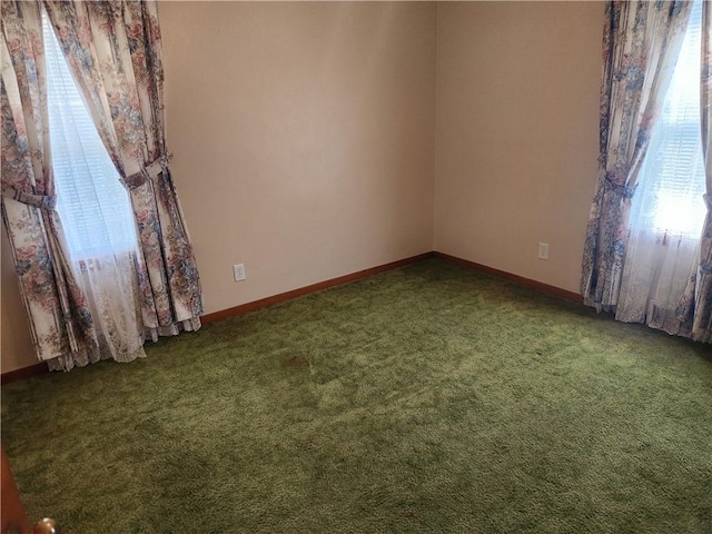 carpeted empty room with a healthy amount of sunlight and baseboards