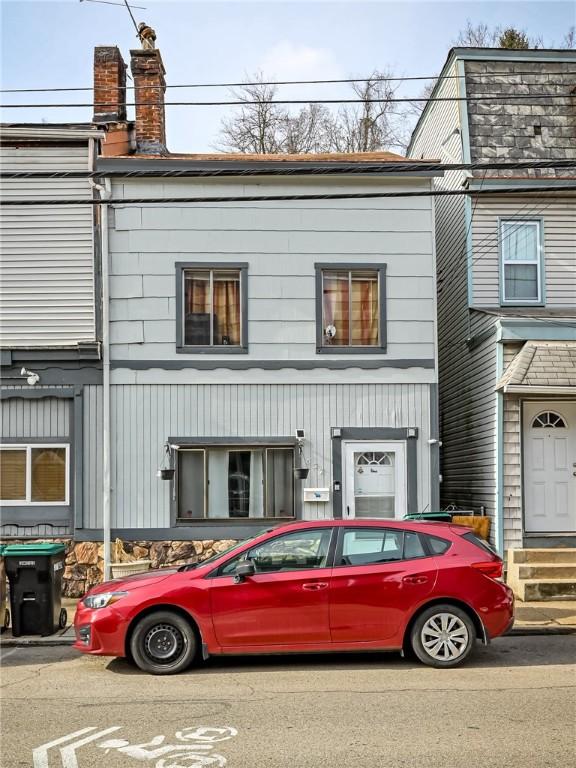 view of front facade with entry steps and a chimney