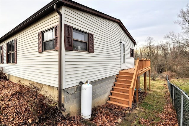 view of side of property with stairs, fence, and a deck