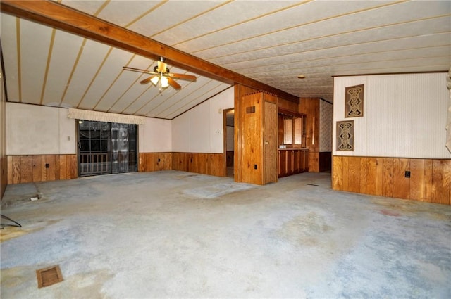 unfurnished room with vaulted ceiling with beams, wainscoting, wood walls, and ceiling fan