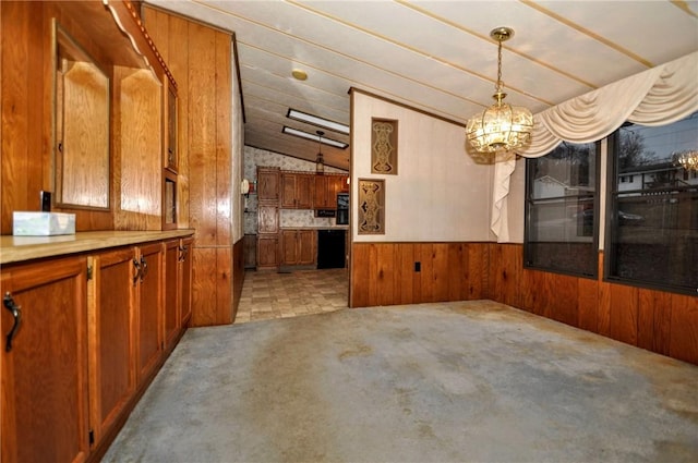 unfurnished dining area featuring a wainscoted wall, light colored carpet, vaulted ceiling, wooden walls, and a chandelier