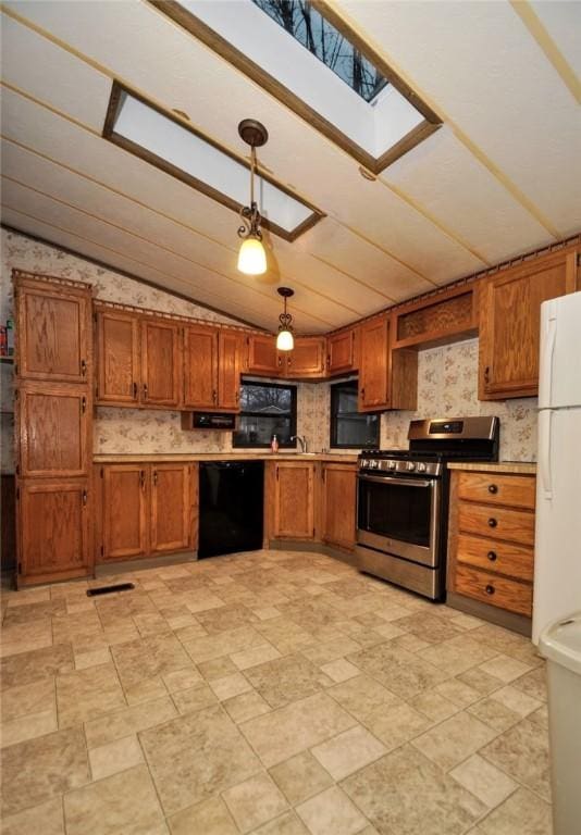 kitchen with hanging light fixtures, stainless steel gas range, freestanding refrigerator, dishwasher, and brown cabinetry