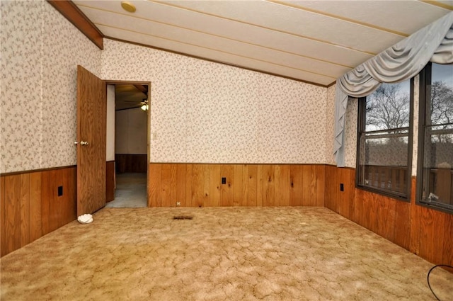 unfurnished room with carpet floors, wainscoting, lofted ceiling with beams, and wallpapered walls