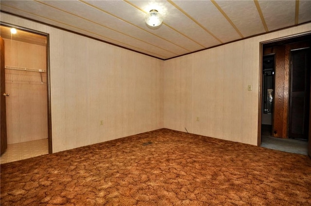 interior space featuring carpet flooring and wooden walls