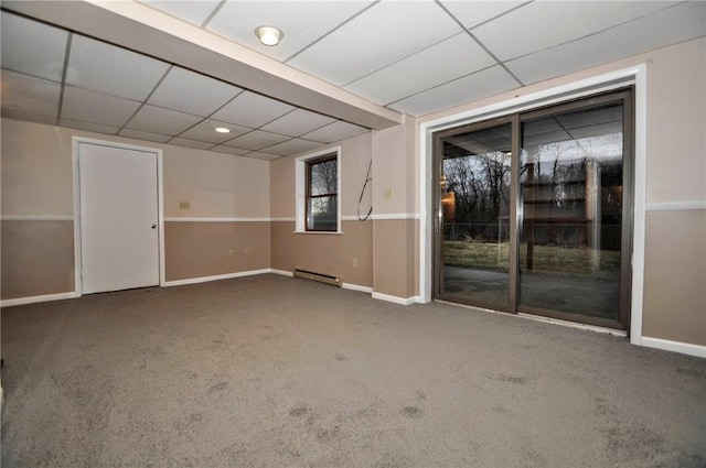 empty room featuring carpet, a drop ceiling, baseboards, and a baseboard radiator