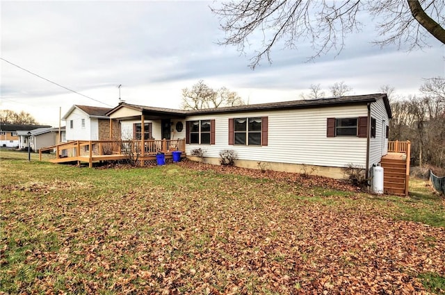 back of house with a deck and a lawn