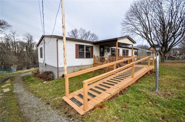 view of front of property featuring a front yard, fence, and a wooden deck