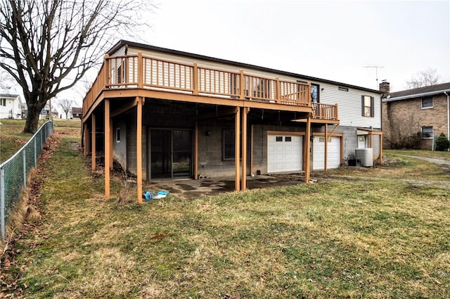 back of house featuring a yard, central air condition unit, an attached garage, fence, and a wooden deck