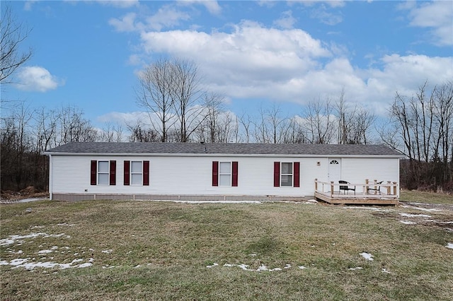 manufactured / mobile home featuring a wooden deck and a front lawn