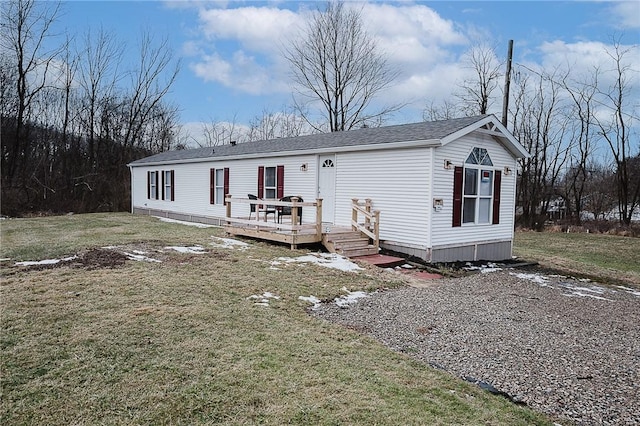 manufactured / mobile home with a front lawn and a wooden deck