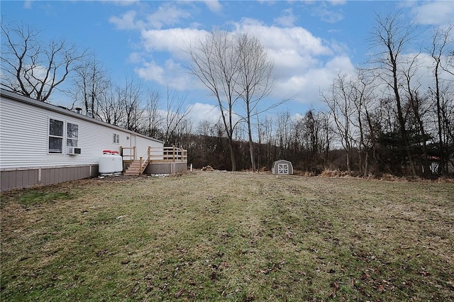 view of yard featuring a storage unit, a deck, cooling unit, and an outdoor structure