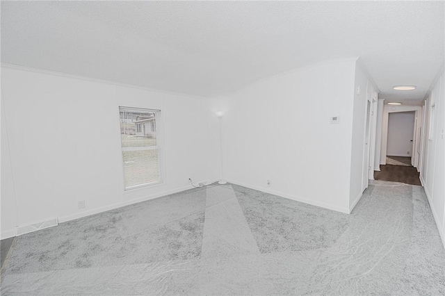 empty room featuring baseboards and a textured ceiling