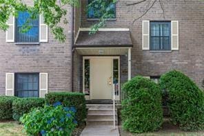 entrance to property featuring brick siding