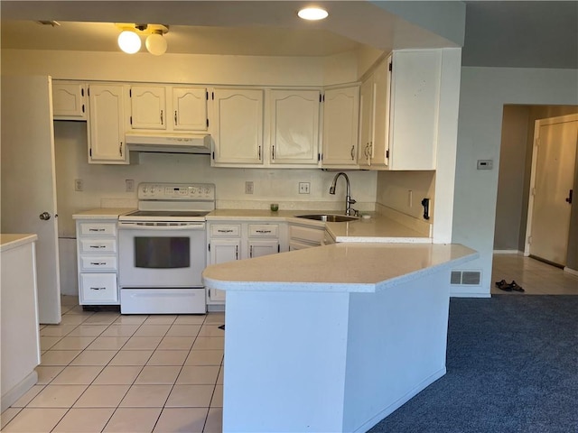 kitchen featuring visible vents, under cabinet range hood, a peninsula, white electric range, and a sink