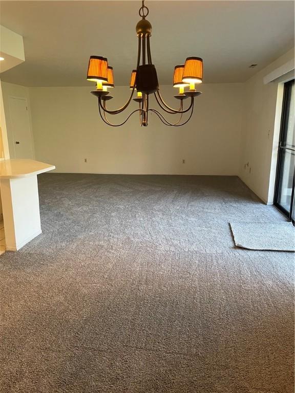 unfurnished dining area featuring carpet and an inviting chandelier