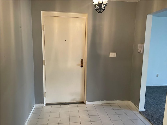 entrance foyer with light carpet, baseboards, and light tile patterned flooring