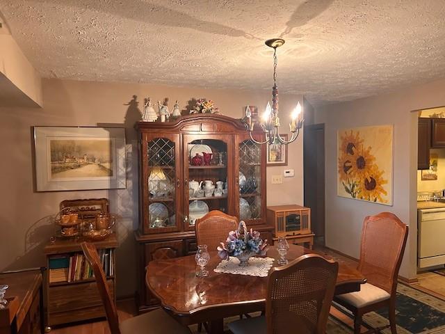 dining space featuring a chandelier and a textured ceiling