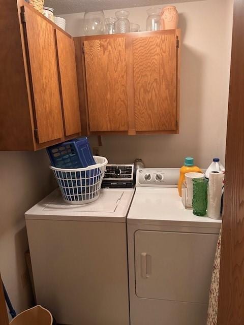 washroom with cabinet space and separate washer and dryer