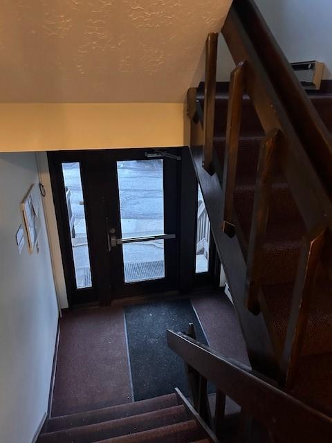 entrance foyer featuring a textured ceiling and stairs