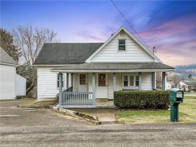 view of front of property with a porch and roof with shingles