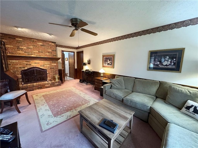 carpeted living room featuring a textured ceiling, a brick fireplace, and a ceiling fan