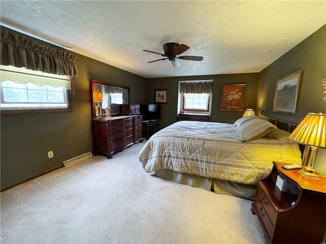 bedroom with light colored carpet, multiple windows, a textured ceiling, and baseboards