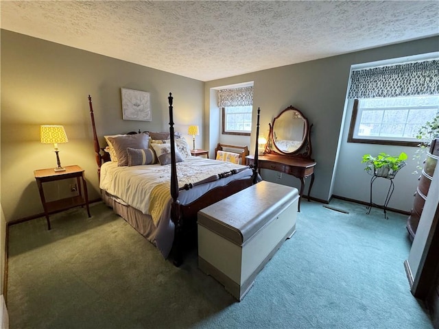 bedroom featuring light colored carpet, a textured ceiling, and baseboards