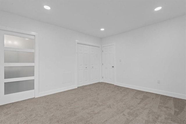 empty room featuring carpet floors, recessed lighting, and baseboards