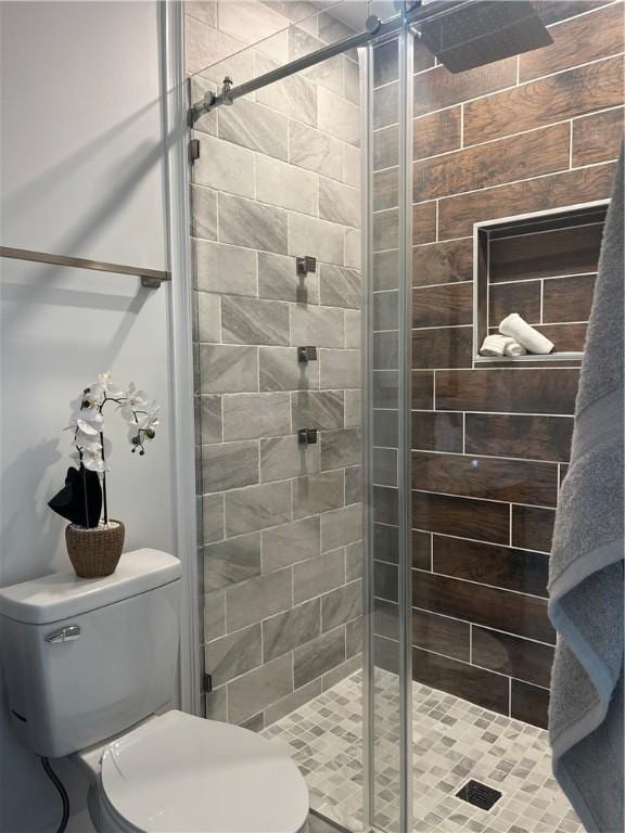 bathroom featuring a stall shower and toilet