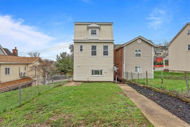 back of house with a fenced backyard and a yard