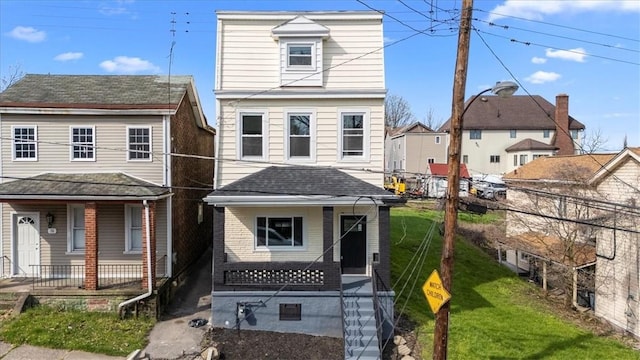 view of front facade featuring covered porch, fence, and a front yard