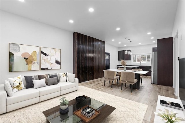 living area with light wood-style flooring and recessed lighting