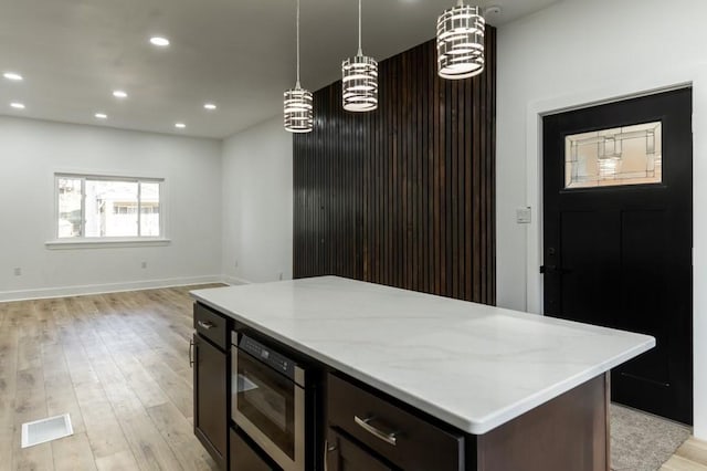 kitchen featuring light wood-style floors, recessed lighting, visible vents, and hanging light fixtures