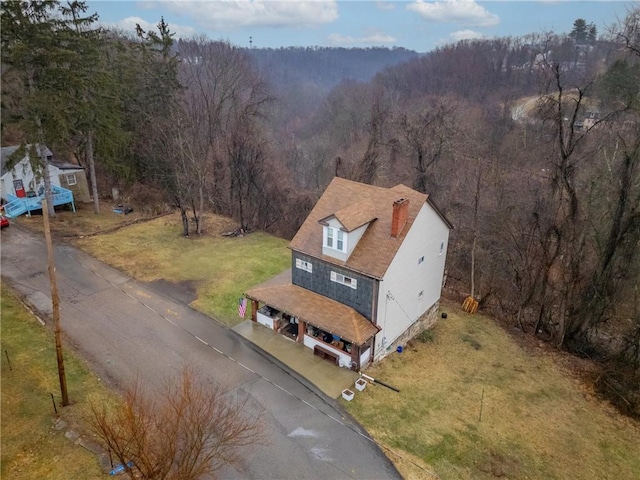 birds eye view of property featuring a forest view