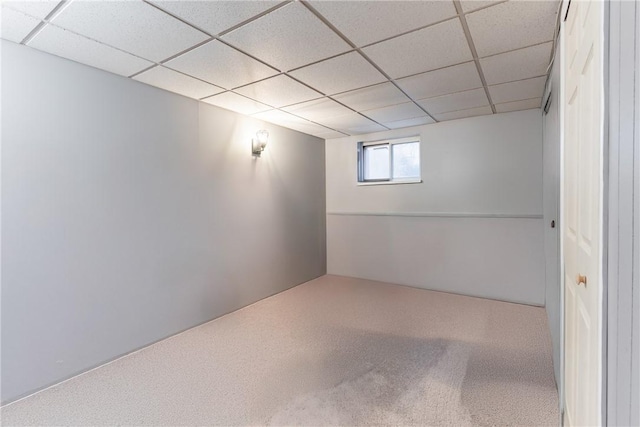 below grade area with a paneled ceiling and carpet flooring