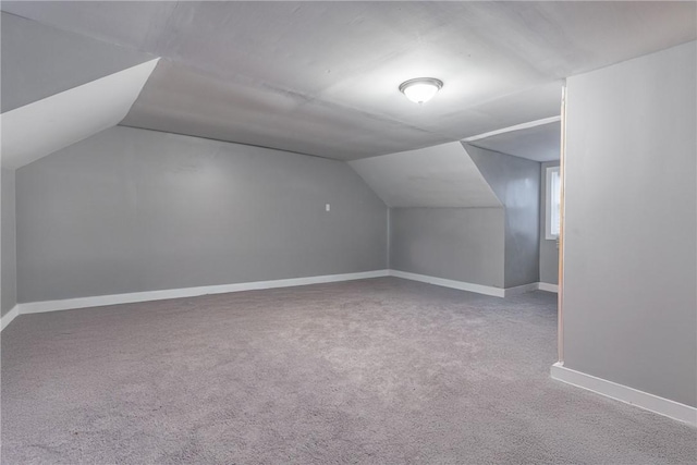 bonus room featuring lofted ceiling, carpet, and baseboards