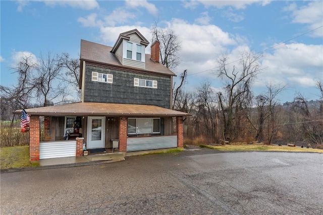 view of front of property featuring a porch and a chimney