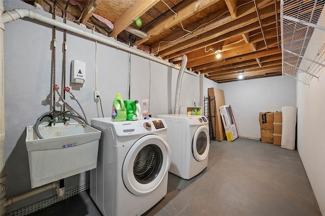 laundry area featuring laundry area, washing machine and dryer, and a sink