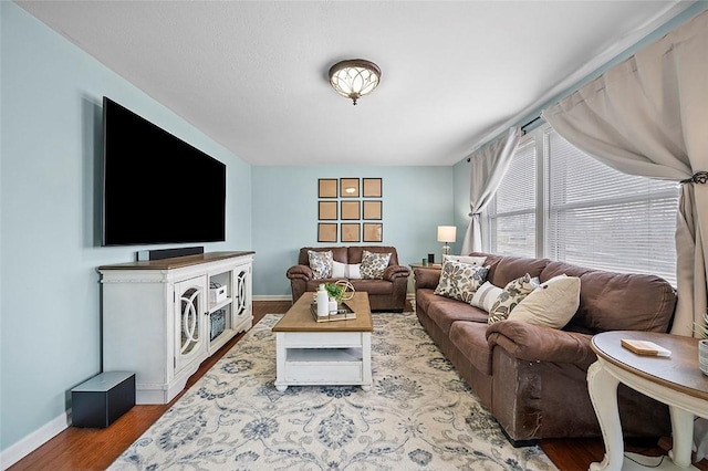 living area with baseboards and wood finished floors