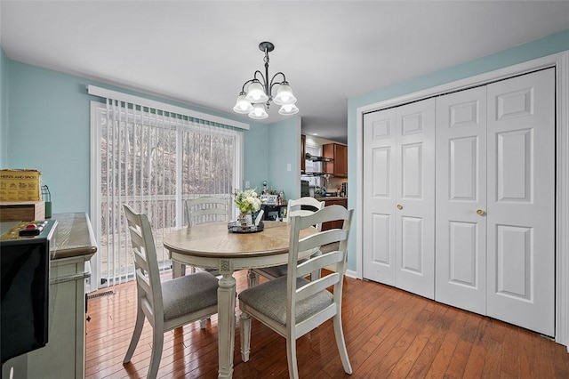 dining area featuring an inviting chandelier and hardwood / wood-style flooring